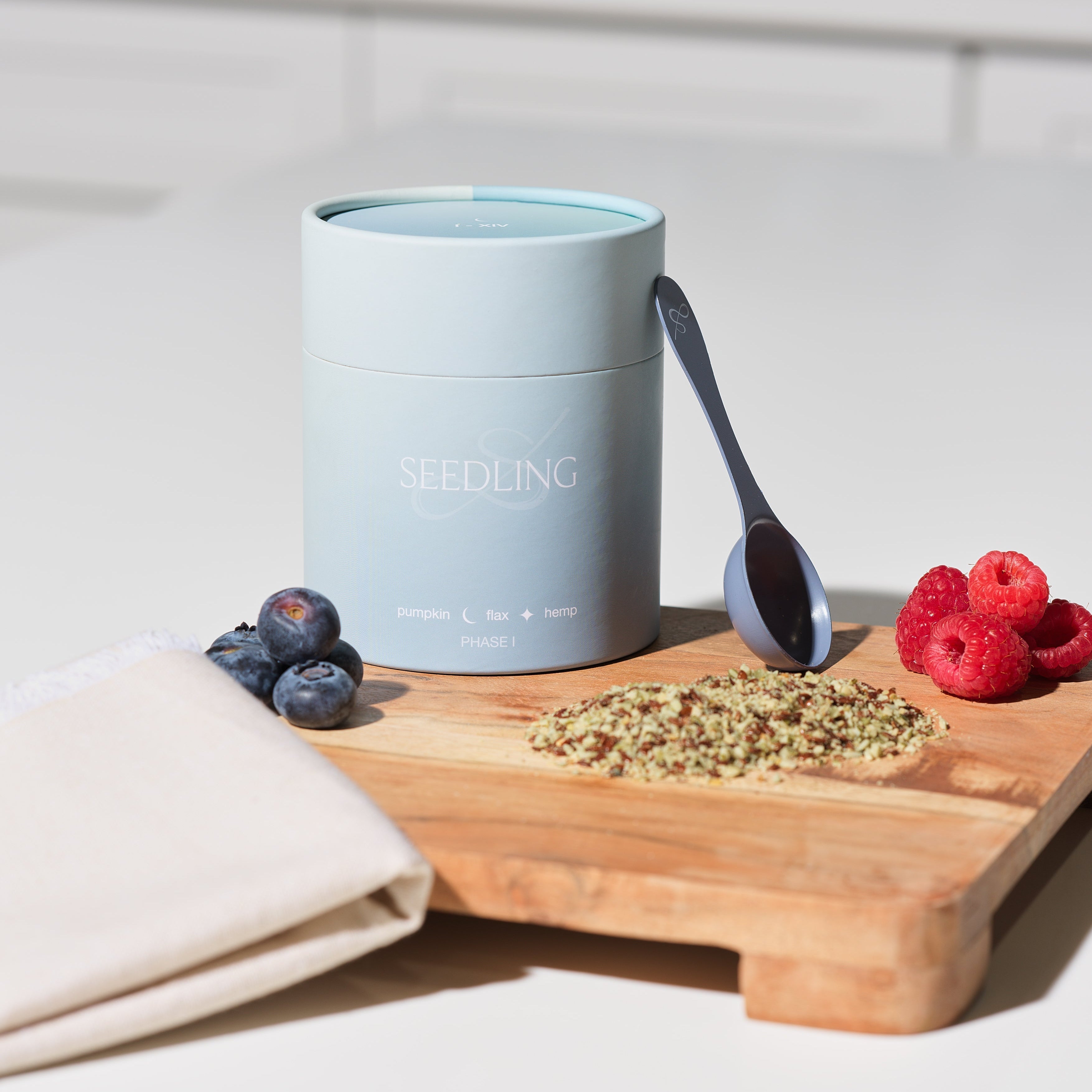 flax, pumpkin, sesame, and sunflower seeds arranged by cycle phase", "Her Seedling seed cycling kit on marble counter"