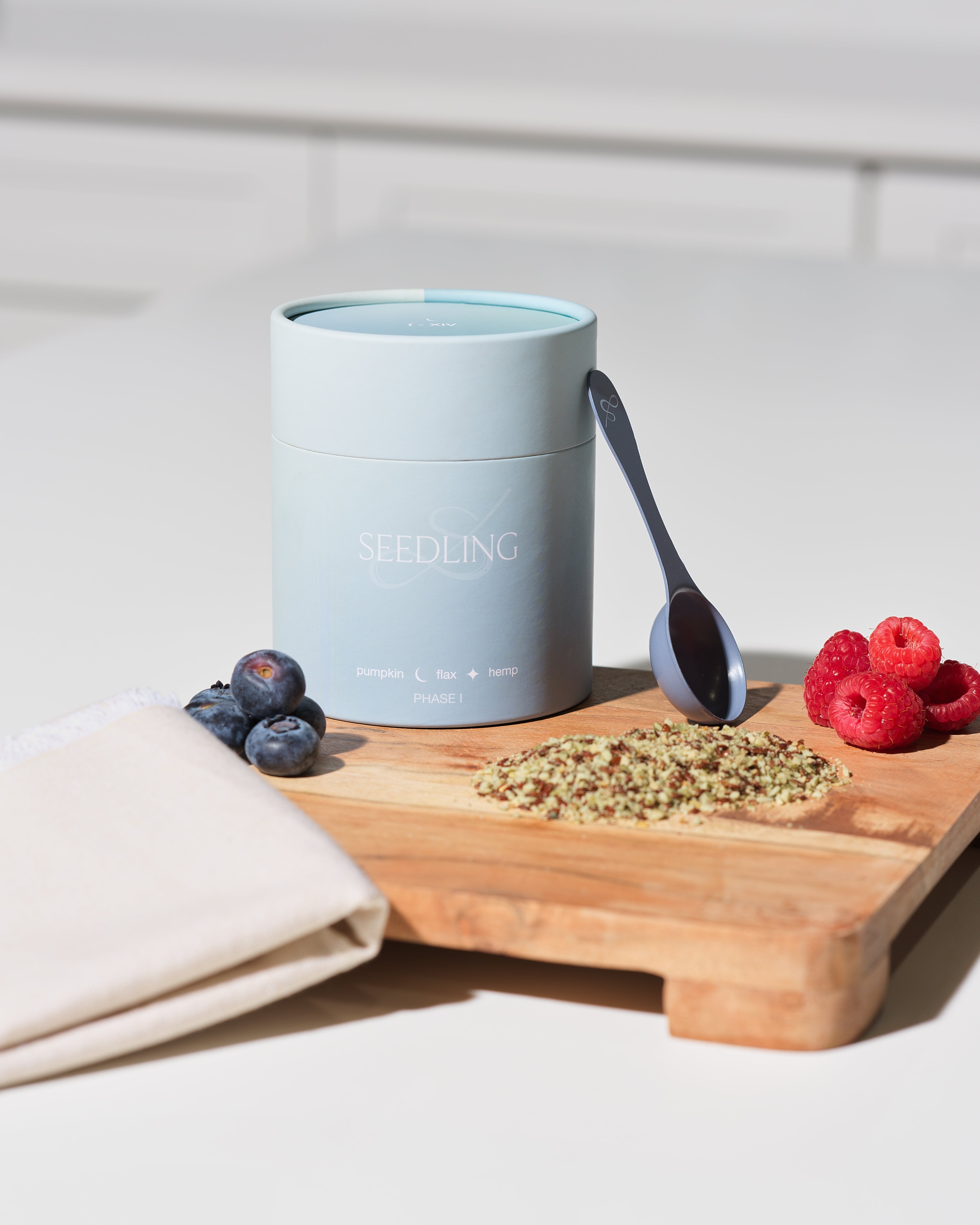 flax, pumpkin, sesame, and sunflower seeds arranged by cycle phase", "Her Seedling seed cycling kit on marble counter"